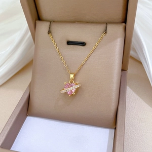 Detail of a gold-plated heart necklace with a pink gemstone in a luxury jewelry box
