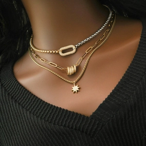 Close-up of layered gold and silver choker with iced-out oval and star pendants