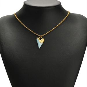 Collana con ciondolo a cuore dorato e trama in marmo azzurro su modello nero