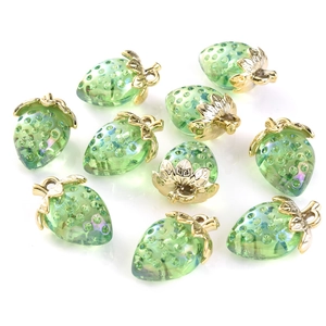 Macro view of transparent strawberry pendants with golden leaves for DIY jewelry making