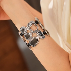 Detail of vintage geometric round silver hollow bracelet with black resin inlay on wrist