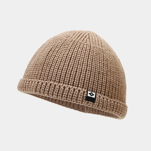 Gros plan d'un bonnet miki en maille camel avec texture côtelée et étiquette noire N