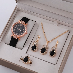Nahaufnahme der roségoldenen Uhr und des Schmucksets mit schwarzen Steinen im Etui