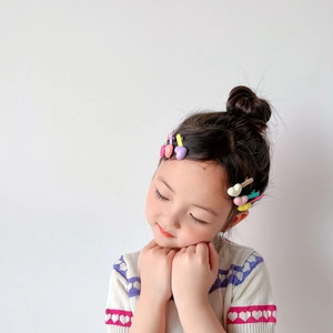 Close-up of colorful heart-shaped candy color hair clips on a young girl hairstyle