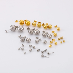 Détail de boucles d'oreilles boules en finitions or et argent de diverses tailles