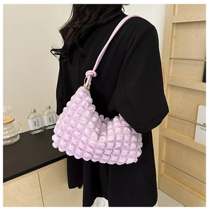 Detail shot of the popcorn texture and lavender hue of this pleated underarm shoulder bag