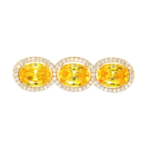 Luxury gold brooch featuring three large oval yellow gemstones with zircon accents on white