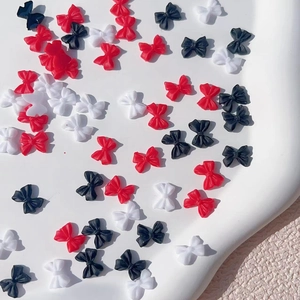 Detail of mixed red black and white resin bow charms for DIY nail art decoration