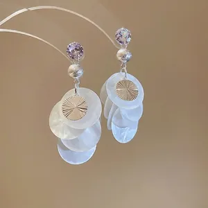 Elegant silver tassel earrings with purple zircon and translucent shell discs in a boho style