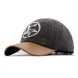 Close-up of distressed star embroidery on vintage washed canvas and faux leather baseball cap
