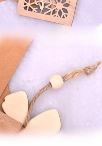Detail of wooden snowflake pendant showing the hollowed back and natural twine hanging rope