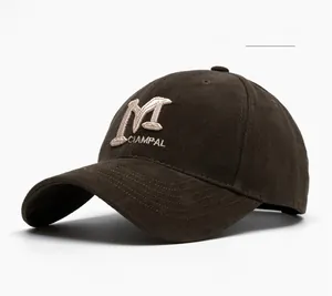 Detail of dark brown cotton baseball cap showing 3D embroidered M letter and fine stitching