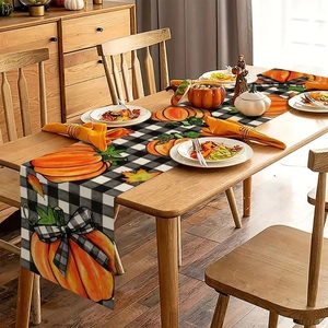 Autumn harvest table runner with pumpkin and maple leaf patterns on black and white plaid