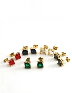 Détail de boucles d'oreilles en zircon carré coloré avec montures dorées à quatre griffes