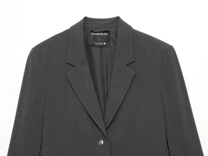 Detail of dark grey blazer featuring notched lapels and fine twill fabric texture