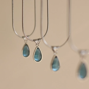 French style silver snake chain necklace featuring blue teardrop crystal pendants