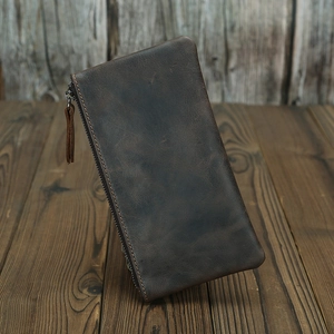 Vertical view of dark brown crazy horse leather wallet on dark wood grain background