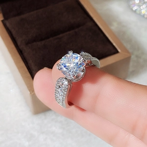 Macro shot of silver bridal ring with round zircon gemstone in four-prong setting