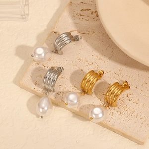 Elegant gold and silver wave-patterned earrings with large white teardrop pearls
