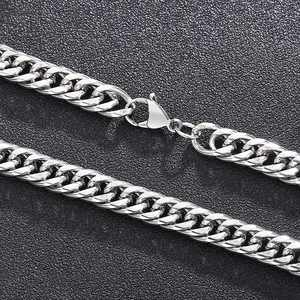 Macro detail of silver curb chain necklace texture with lobster clasp on black background