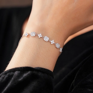 Detail of silver floral bracelet with square cubic zirconia on a female wrist