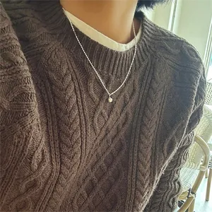 Close-up of a minimalist 925 silver beaded necklace with a round ball pendant on a sweater