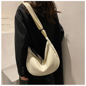 Detail of adjustable strap and smooth leather texture on the beige hobo dumpling bag