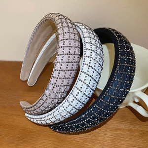 Close-up of thick fabric headbands with sparkling rhinestones in pink, white, and black colors