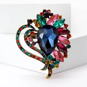 Macro view of multi-color vintage crystal brooch with detailed gold metallic base setting