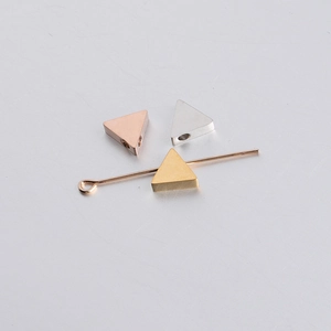 Macro detail of triangle mirror finish stainless steel beads in gold, rose gold and silver