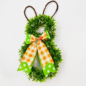 Detail of Easter bunny wreath with green foliage and orange checkered bow decoration