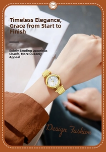 Detailed close-up of a ladies gold quartz watch with a white mother of pearl dial face