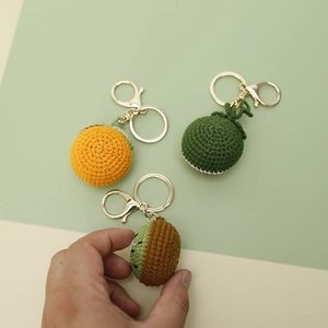 Handmade crochet fruit keychains featuring orange and kiwi designs with gold rings