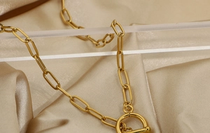 Detailed macro shot of gold plated stainless steel paperclip chain with OT toggle clasp