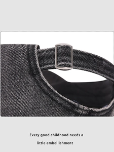 Detailed macro shot of the adjustable metal buckle and stitching on the denim baseball cap