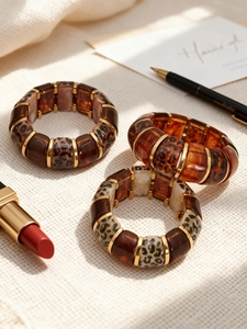 Detail of leopard print resin bangles with gold metal spacers on soft waffle fabric