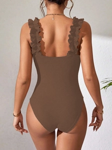 Detail of dark brown ribbed knit bodysuit featuring elegant ruffled shoulder straps on back