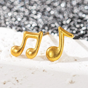 Vue macro de boucles d'oreilles notes de musique en acier inoxydable plaqué or 18 carats