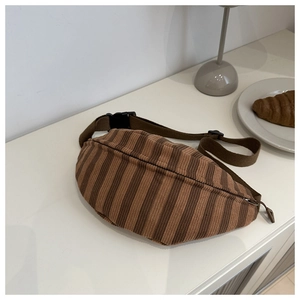 Detail of striped corduroy texture on brown crossbody bag with adjustable black strap