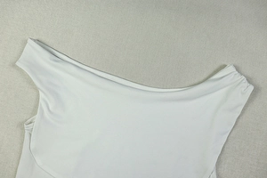 Detail view of white one-shoulder neckline with elegant ruched pleats and fine stitching