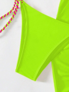 Detailed close-up of neon green bikini fabric with pink and green braided ties