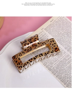 Macro detail of a rectangle leopard print hair claw clip made of glossy acrylic material