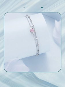 Macro detail of silver double-layer bracelet with heart pink gemstone and silver beads