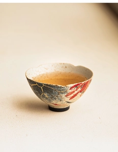 Detail of hand-painted floral ceramic teacup with elegant gold accents and koi fish motif