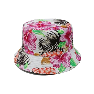 Détail d'un chapeau bob avec motifs de fleurs d'hibiscus roses et de feuilles de palmier