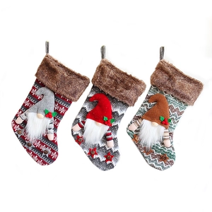 Set of three knit Christmas stockings with 3D plush gnomes and faux fur cuffs
