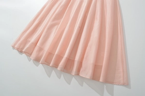 Detail of the pink sleeveless dress featuring soft pleats and lightweight chiffon fabric