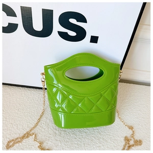 Dettaglio mini borsa a secchiello verde in PVC con motivo trapuntato e catena dorata