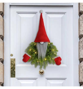 Illuminated Christmas gnome wreath with LED lights hanging on a white wooden front door