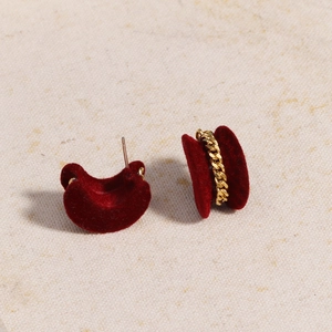 Detailed view of burgundy velvet heart-shaped earrings with gold chain link texture